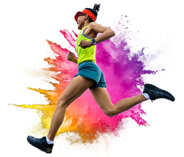 Woman running with colourful paint splash in the background